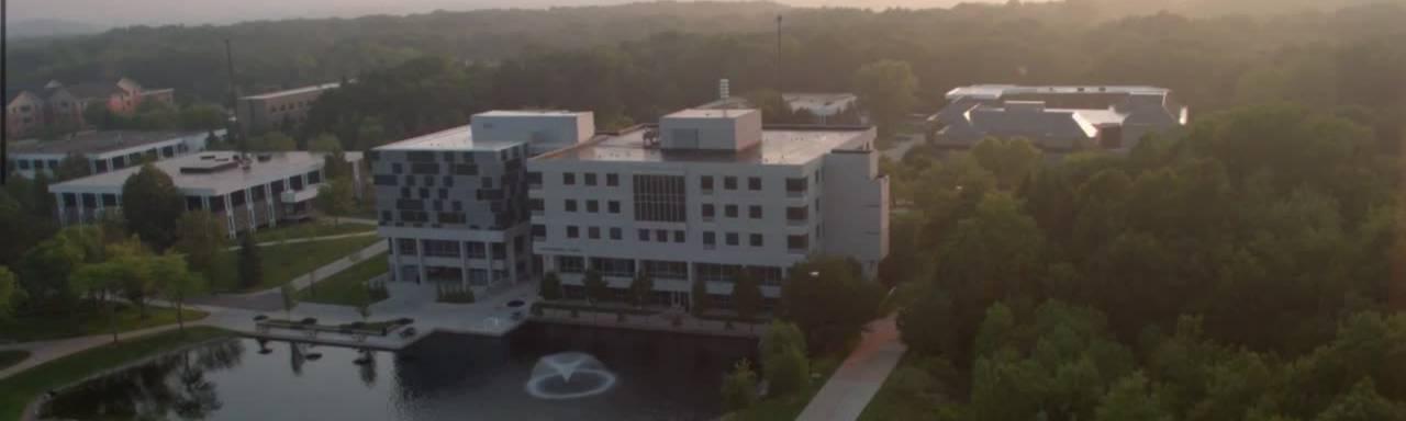 一个小池塘附近灰色和蓝色的方形建筑的航拍照片. Zumberge Hall on GVSU's Allendale Campus